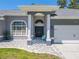 Charming front entrance with pillars, a gray tiled walkway, and double doors offers appealing curb appeal at 4951 Musselshell Dr, New Port Richey, FL 34655