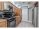 Kitchen with wood cabinets, black appliances, granite countertops, and tile flooring at 4951 Musselshell Dr, New Port Richey, FL 34655