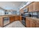 Bright kitchen featuring wood cabinets, granite countertops, and black appliances at 4951 Musselshell Dr, New Port Richey, FL 34655
