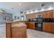 Bright kitchen showcasing wooden cabinets, black appliances, and granite countertops at 4951 Musselshell Dr, New Port Richey, FL 34655