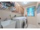 Functional laundry room featuring a washer, dryer, sink, and storage cabinets above appliances at 4951 Musselshell Dr, New Port Richey, FL 34655