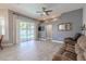 Open living room featuring sliding glass doors to the pool and a modern ceiling fan at 4951 Musselshell Dr, New Port Richey, FL 34655