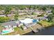Aerial view of a waterfront home with a white roof, dock, and backyard pool in a residential neighborhood at 5816 Liverpool Dr, Tampa, FL 33615