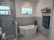 This bathroom features patterned tile, a freestanding tub and a glass-enclosed shower at 5816 Liverpool Dr, Tampa, FL 33615