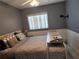 Bedroom featuring a comfortable bed with a patterned comforter and a bright window with blinds at 5816 Liverpool Dr, Tampa, FL 33615