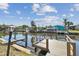Waterfront property featuring a private wooden dock and canal access on a sunny day with blue skies at 5816 Liverpool Dr, Tampa, FL 33615