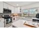 A well-lit kitchen featuring white cabinets, stainless steel appliances, and view from the window at 5816 Liverpool Dr, Tampa, FL 33615