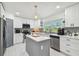 Bright kitchen features white cabinets, stainless steel appliances, island, and window view at 5816 Liverpool Dr, Tampa, FL 33615