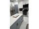 This kitchen features white cabinets, stainless steel appliances, and a gray kitchen island with a white countertop at 5816 Liverpool Dr, Tampa, FL 33615