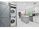A full kitchen with a laundry area featuring white cabinets, stainless steel appliances, and center island at 5816 Liverpool Dr, Tampa, FL 33615