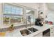 This kitchen has stainless steel sink and modern fixtures complemented by a view from the window over the countertop at 5816 Liverpool Dr, Tampa, FL 33615