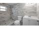 Newly remodeled bathroom featuring stylish gray tiling in the shower, floor, and walls at 660 Palm Ave, Tarpon Springs, FL 34689