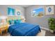 Comfortable bedroom featuring bright blue bedding, natural light from a large window, and stylish decor at 660 Palm Ave, Tarpon Springs, FL 34689
