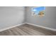 This empty bedroom features new wood floors, grey paint and a view outside the window at 660 Palm Ave, Tarpon Springs, FL 34689