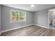 This cozy bedroom is painted gray and features new wood floors and a view of the backyard at 660 Palm Ave, Tarpon Springs, FL 34689