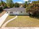 Charming single story home with a paved walkway, well-kept lawn, and an attached carport at 660 Palm Ave, Tarpon Springs, FL 34689