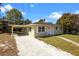 Charming single-story home with attached carport and gravel driveway at 660 Palm Ave, Tarpon Springs, FL 34689