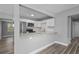 Modern kitchen with white cabinetry, stainless steel appliances, and a view of the living space and backyard at 660 Palm Ave, Tarpon Springs, FL 34689
