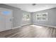 Bright and airy living room featuring wood-look floors and ample sunlight streaming through the large windows at 660 Palm Ave, Tarpon Springs, FL 34689