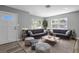 Inviting living room featuring neutral gray walls, wood-look flooring, plush seating, and large windows with natural light at 660 Palm Ave, Tarpon Springs, FL 34689