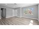Bright living room with gray walls, wood floors, a cozy couch, natural light, and a view of the outdoors at 660 Palm Ave, Tarpon Springs, FL 34689