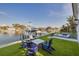 Lush backyard with outdoor seating around a fire pit, a boat dock, and a waterfront view at 721 Brightwaters Ne Blvd, St Petersburg, FL 33704