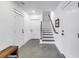 Finished basement featuring a staircase, concrete floors, and white doors with black hardware at 721 Brightwaters Ne Blvd, St Petersburg, FL 33704