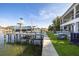 Waterfront property featuring a boat dock, lush lawn, and inviting outdoor lounge chairs at 721 Brightwaters Ne Blvd, St Petersburg, FL 33704