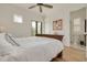 Bright main bedroom with wooden floors, ceiling fan, and access to an ensuite bathroom and outdoor patio at 721 Brightwaters Ne Blvd, St Petersburg, FL 33704
