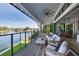 Covered porch overlooking the water with comfortable seating, ceiling fan, and wood flooring at 721 Brightwaters Ne Blvd, St Petersburg, FL 33704