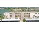 Exterior view of 'The Saratoga' condo building featuring balconies and parking spaces on a sunny day at 7645 Sun Island S Dr # 207, South Pasadena, FL 33707