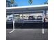 View of the covered parking area showing assigned parking spaces, shade and nearby landscaping at 7645 Sun Island S Dr # 207, South Pasadena, FL 33707