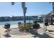 Community BBQ area featuring charcoal grills with waterfront view to dock and nearby condos at 7645 Sun Island S Dr # 207, South Pasadena, FL 33707