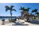 Community barbecue area with charcoal grills, picnic tables, waterfront views and shady palm trees at 7645 Sun Island S Dr # 207, South Pasadena, FL 33707