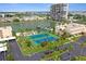 Aerial view of community tennis courts surrounded by lush landscaping near the water at 7645 Sun Island S Dr # 207, South Pasadena, FL 33707