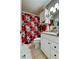 Cozy bathroom featuring granite countertops, a white cabinet, and a red floral shower curtain at 8198 Terrace Garden N Dr # 109, St Petersburg, FL 33709