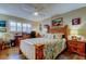 Comfortable bedroom featuring wood furnishings, ceiling fan, and a large window providing natural light at 8198 Terrace Garden N Dr # 109, St Petersburg, FL 33709