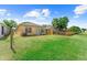 Backyard view featuring the rear of the house, air conditioning condenser, fence, and lush green grass at 8420 Deer Chase Dr, Riverview, FL 33578