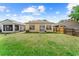 Spacious backyard featuring a grassy area, the house's rear facade and the side of a neighboring screen porch at 8420 Deer Chase Dr, Riverview, FL 33578