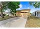 Home exterior featuring a two-car garage and well-manicured lawn at 8420 Deer Chase Dr, Riverview, FL 33578