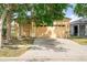 Exterior view of the house featuring a 2 car garage with exterior lights, driveway, and lush front yard with mature trees at 8420 Deer Chase Dr, Riverview, FL 33578