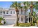 Charming two-story home featuring a double porch, painted in a light pink, with palm trees in the front yard at 916 Hemingway Cir, Tampa, FL 33602