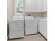 Bright laundry room with washer, dryer, white cabinets, and a window for natural light at 916 Hemingway Cir, Tampa, FL 33602