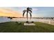 Scenic backyard with a white picket fence, fire pit, and views of the serene lake at sunset at 9416 Star Gazer Ln, Riverview, FL 33578