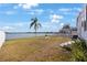 Relaxing backyard featuring a white picket fence, palm tree, lakeside views, and outdoor seating at 9416 Star Gazer Ln, Riverview, FL 33578