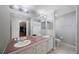 Bathroom with double sinks, ample lighting, neutral tile and an open doorway at 9416 Star Gazer Ln, Riverview, FL 33578