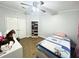 Bedroom featuring wood-look floors, storage shelf, desk, ceiling fan and closet at 9416 Star Gazer Ln, Riverview, FL 33578