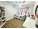 Bright bedroom with wood-look floors, a ceiling fan and a large desk space at 9416 Star Gazer Ln, Riverview, FL 33578