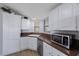 Well-equipped kitchen with white cabinets, updated appliances, and ample counter space for cooking at 9416 Star Gazer Ln, Riverview, FL 33578