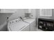 Functional laundry area with white appliances, built-in storage, and efficient layout for everyday chores at 9416 Star Gazer Ln, Riverview, FL 33578